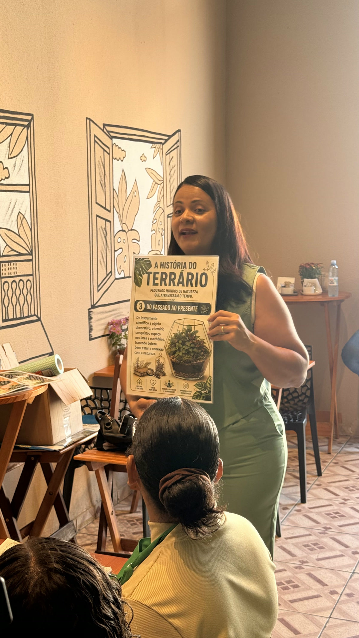 Ana mostrando o cartaz A história do terrário