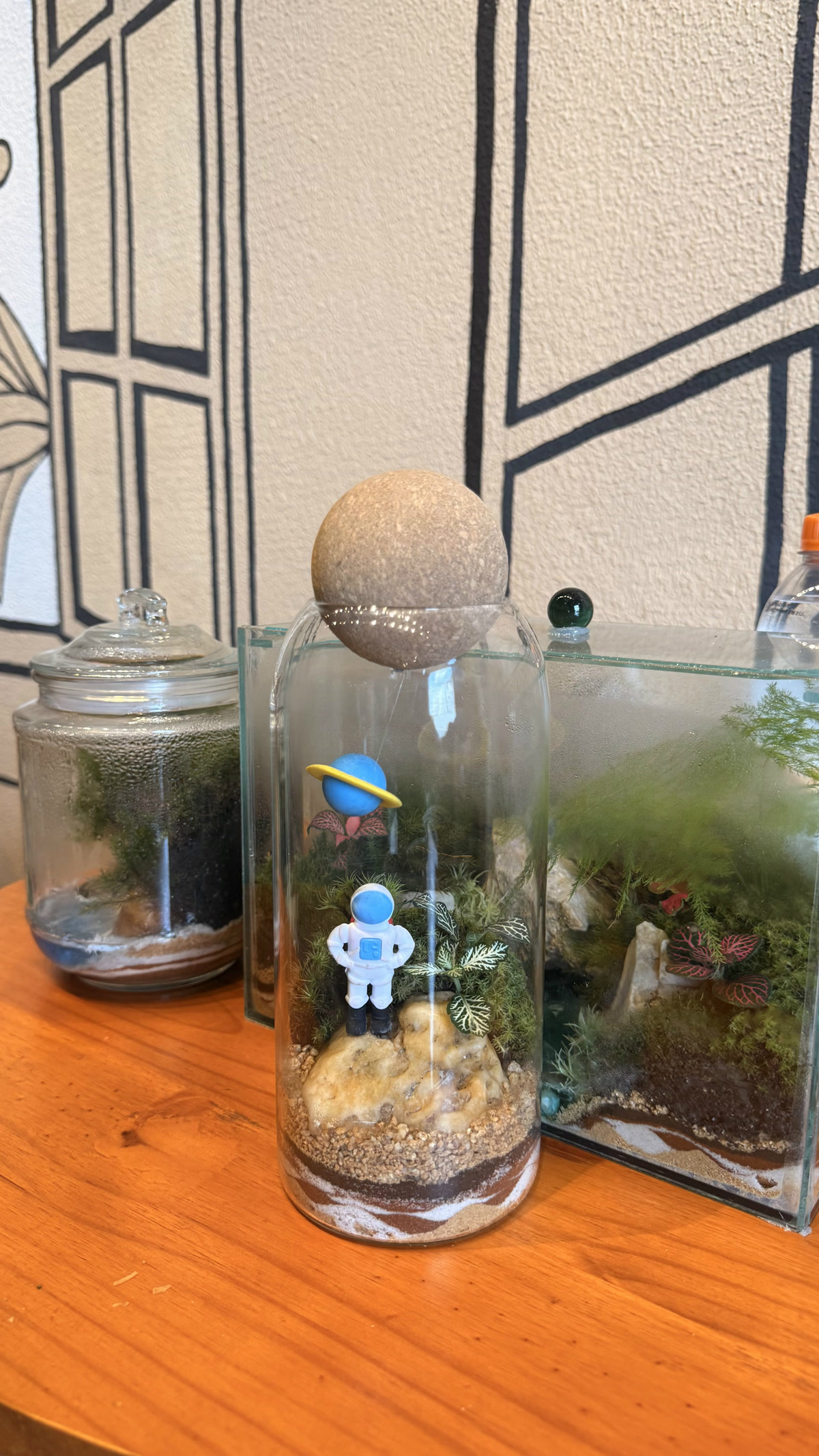 Terrário em cilindro com um astronauta em miniatura